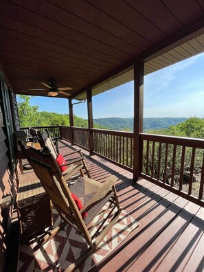 A covered porch with wooden flooring, a railing, and wicker furniture. - Panoramic views•Endless relaxation! Blue Ridge Pky (Purlear)