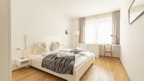 A modern bedroom with a white bed, a desk, and a chair. - Chalet # 19 for up to 8 people with IR- Sauna (St. Lambrecht)