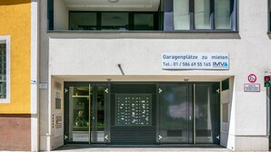 Un bâtiment portant une enseigne indiquant un espace de stationnement pour les véhicules et un numéro de téléphone à contacter pour l’IMVA.