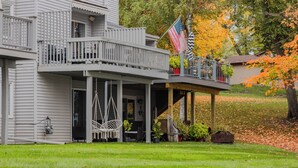 A two-story house with a balcony, a hanging chair, and a flag. - Spacious 4 bedroom on Lake Le Home Dieu (Alexandria)