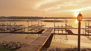 A wooden pier extending into calm water with a lamp post and a covered seating area. - Spacious 4 bedroom on Lake Le Home Dieu (Alexandria)