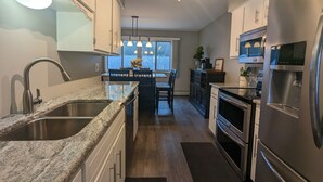 A modern kitchen with granite countertops, stainless steel appliances, and a central island. - Spacious 4 bedroom on Lake Le Home Dieu (Alexandria)