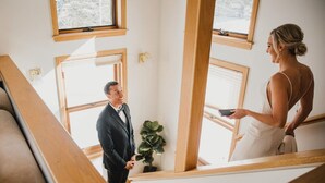 Ein modernes Interieur mit großen Fenstern, einer Treppe und einem Blumentopf.