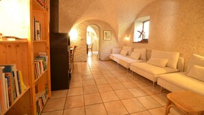 A cozy living room with a white sofa, a bookshelf, and a fireplace. - Magnificent detached chalet★7 bedrooms★prox. Alpe d'Huez (LE BOURG D'OISANS)