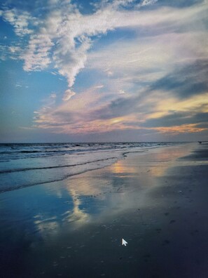Uma praia com vista para o mar e o céu.