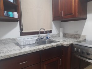 Een koelkast, een oven, een kookplaat, een koffiezetapparaat/waterkoker