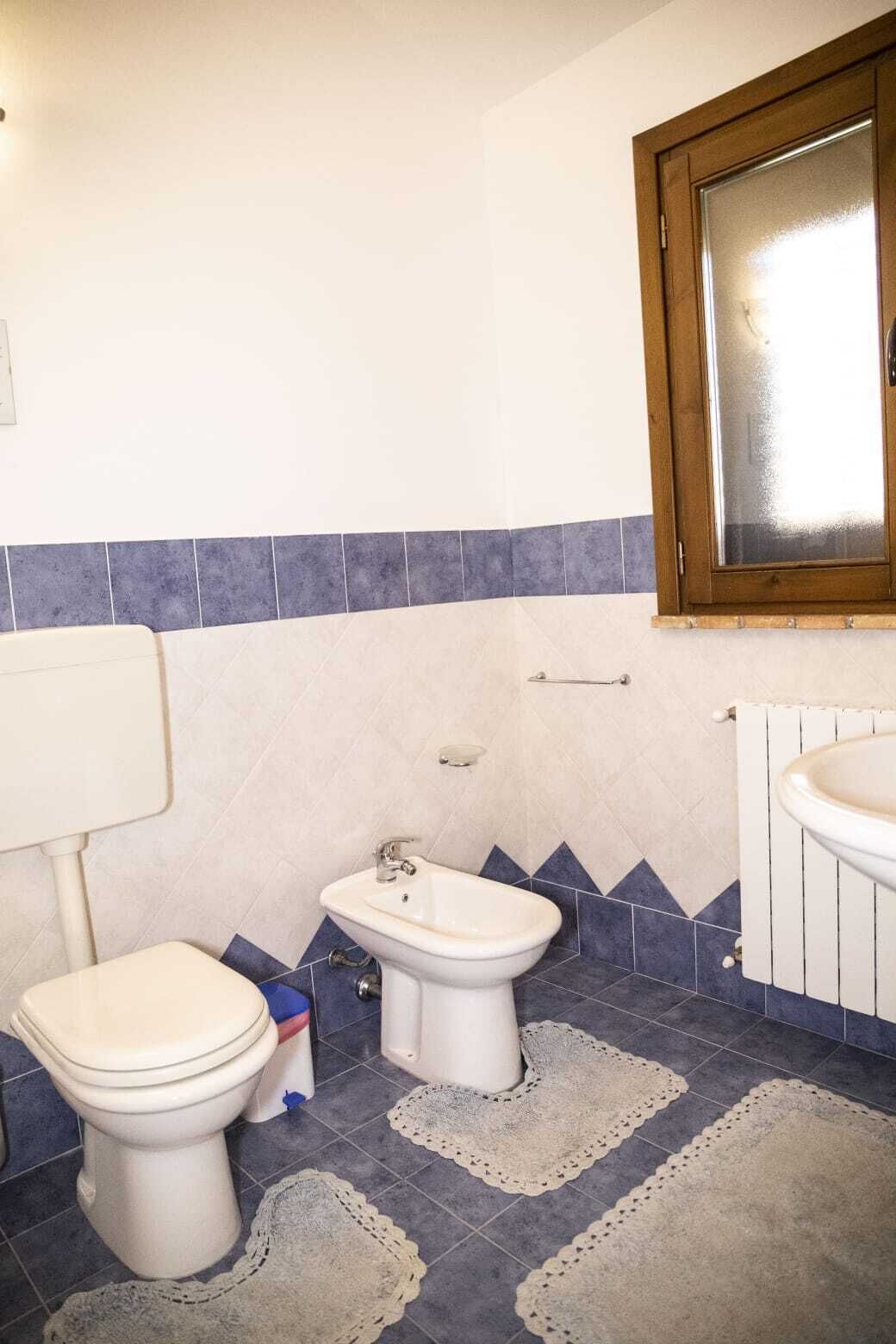 Een badkamer met toilet, bidet en wastafel.