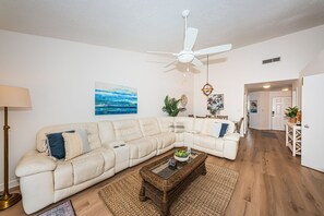 A living room with a sectional sofa, a coffee table, and a ceiling fan. - VV 5B-241 - Vista Verde East - Premium (St Petersburg)