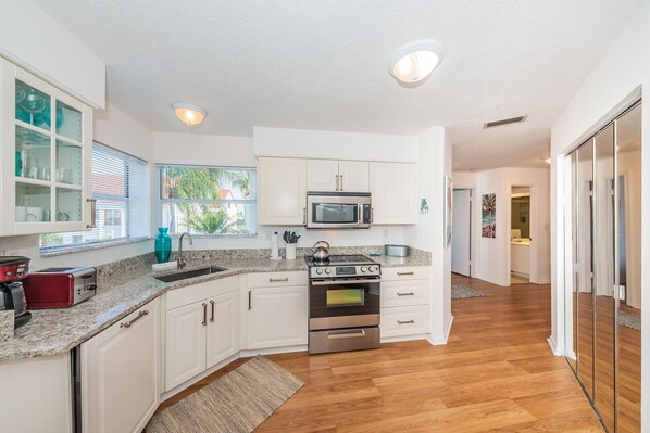 Enjoy cooking in this well-equipped kitchen with a window, sink, and stainless steel appliances.
