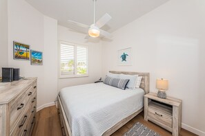 A bedroom with a bed, a nightstand, a desk, a ceiling fan, and two wall-mounted pictures. - VV 5B-241 - Vista Verde East - Premium (St Petersburg)