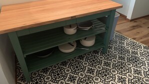 A kitchen with a wooden countertop, green cabinets, and patterned floor tiles. - Comfortable and Quaint w/ a Hot Tub (Brookings)