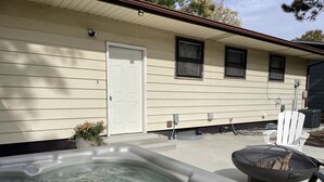 A hot tub in front of a house with a door and windows. - Comfortable and Quaint w/ a Hot Tub (Brookings)