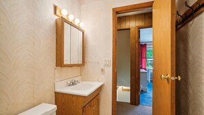 A bathroom with a vanity, sink, mirror, and lights. - 2 bedroom Killington condo with fireplace, kitchen, and Wi-Fi. (Killington)