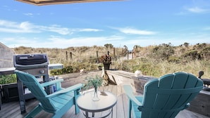 A deck with two turquoise Adirondack chairs, a small round table, and a grill. - Remote Oceanfront Retreat Between Santa Cruz & Monterey (Watsonville)