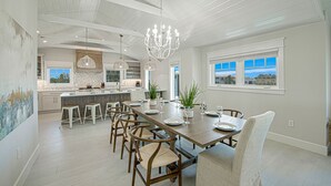 A spacious kitchen with a central island, pendant lighting, and a view of the outside. - Nearly Beachfront, One house from the beach! Pool and Game Room - Ocean Overlook (Siesta Key)