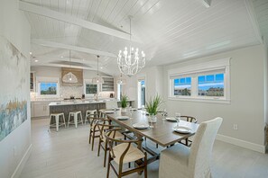 A spacious kitchen with a central island, pendant lighting, and a view of the outside.