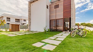Une maison moderne avec une pelouse bien entretenue et un vélo garé devant.