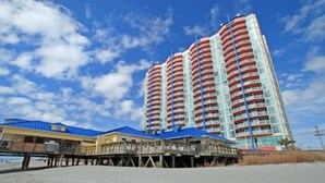Un hotel moderno de gran altura con varios balcones y ubicación frente a la playa.