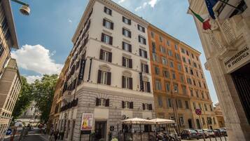 A multi-story building with a classic architectural style, featuring a mix of white and orange facades.