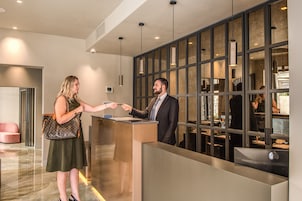 Un mostrador de recepción de diseño moderno, con un separador de vidrio y vistas al espacio interior.