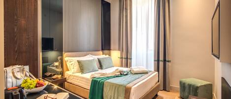 Una habitación de hotel moderna con una cama grande, mesitas de noche, un escritorio con cafetera y vistas a la ciudad.