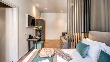 A modern hotel room with a bed, a desk, a TV, and a view of the city.