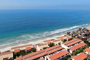 A coastal residential area with buildings having red-tiled roofs, a beach, and the ocean. - Oceanfront Views, Heated Pool, Hot Tubs, BBQ (Solana Beach)