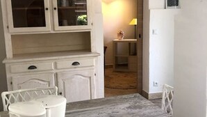 Eine rustikale Küche mit weißen Schränken, einem Holztisch und einer dekorativen Schale.