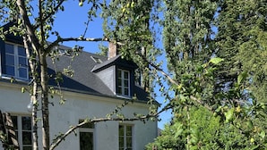 Ein Haus mit Garten, einem gepflasterten Weg und Blumentöpfen.