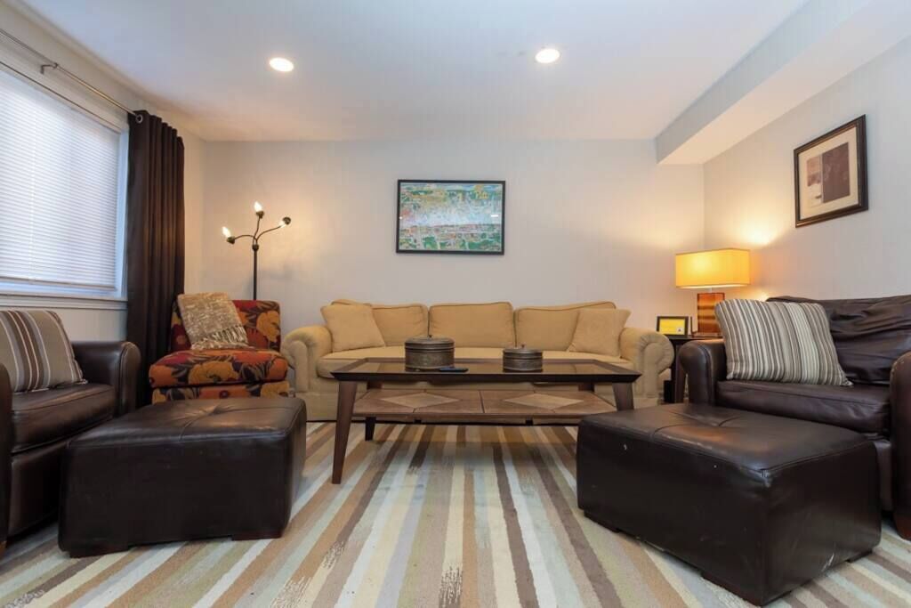 A living room with a sofa set, a coffee table, and a striped rug.