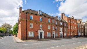 A red brick building with multiple windows and doors, a clear sky, and a paved street. - Bootham Urban Space -  a family break that sleeps 4 guests  in 2 bedrooms (York)