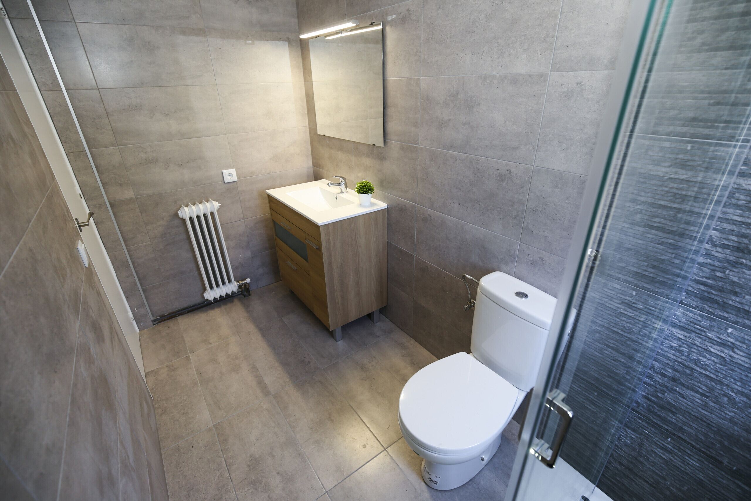 A modern bathroom with a toilet, sink, and shower area.