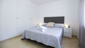 A bedroom with a bed, nightstands, and a wardrobe. - Villa  ADELFA (Salou)