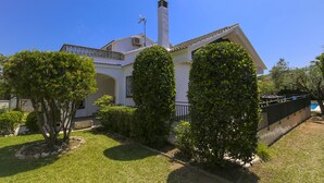A white house with a tiled roof, a chimney, and a small balcony. - Villa  ADELFA (Salou)