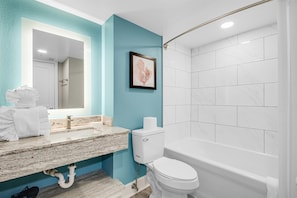 A bathroom with a marble sink, a toilet, and a shower. - Grand Cayman by Escape (Myrtle Beach)