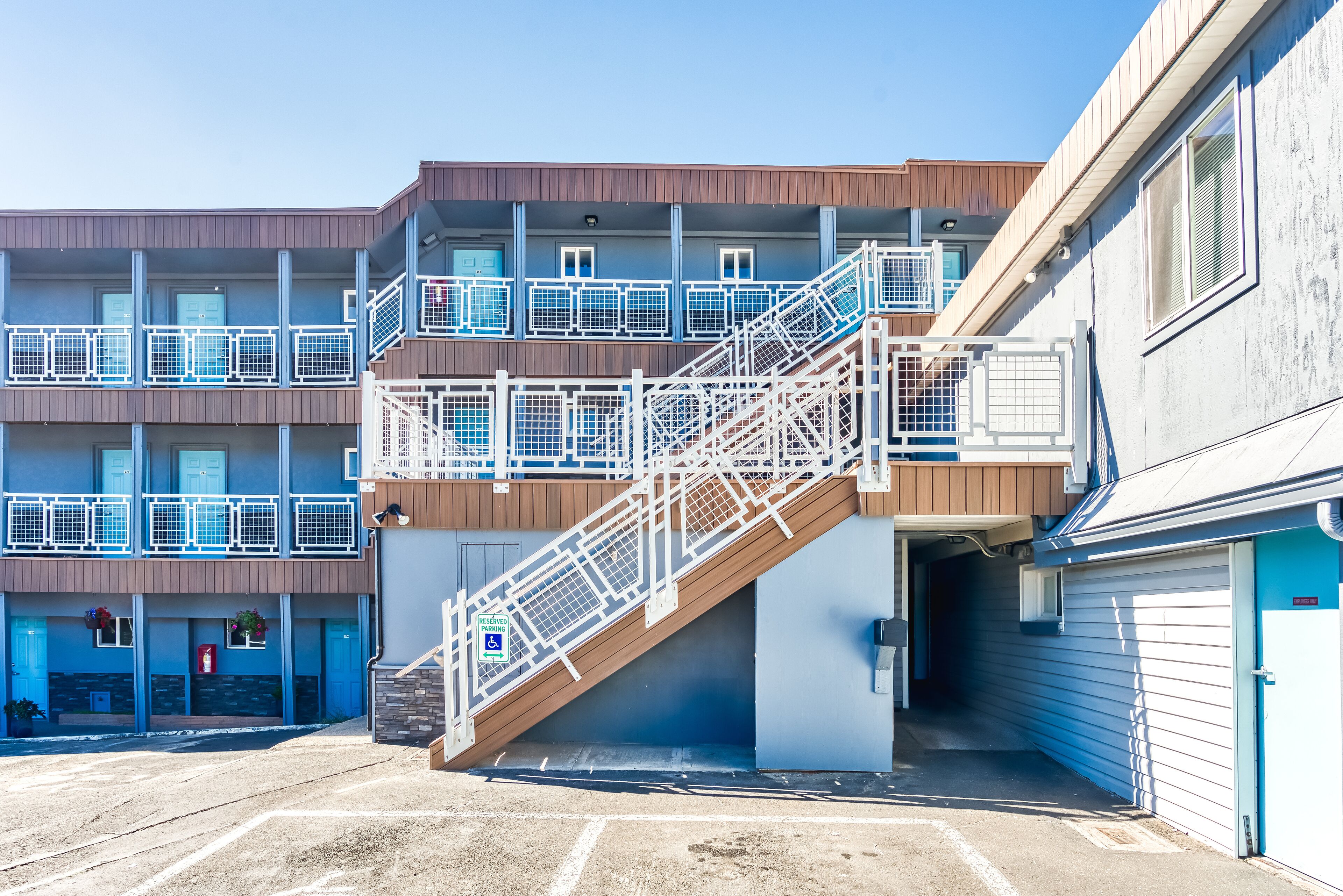 Un immeuble à plusieurs étages doté d’un escalier central, d’un parking et d’une porte de garage.