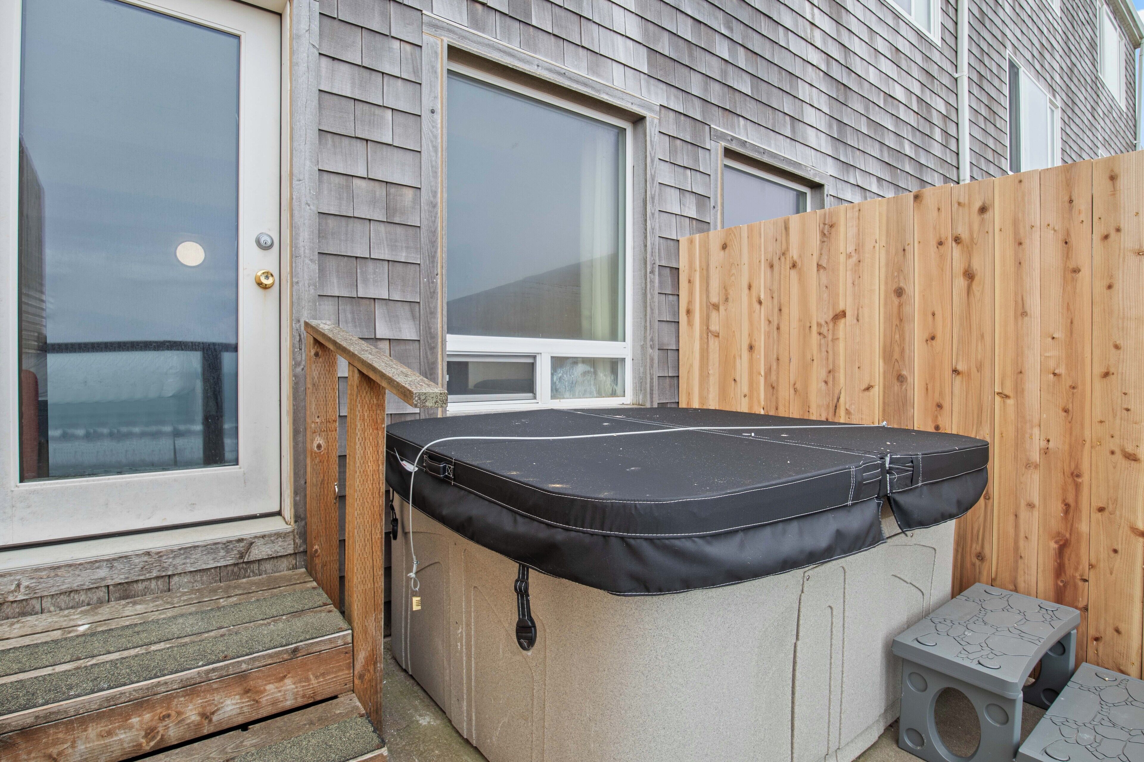 Un bain à remous dans un jardin, avec une terrasse en bois et une clôture en bois.