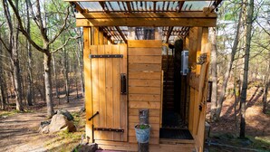 Una cabaña de madera con puerta de madera y un pequeño porche.