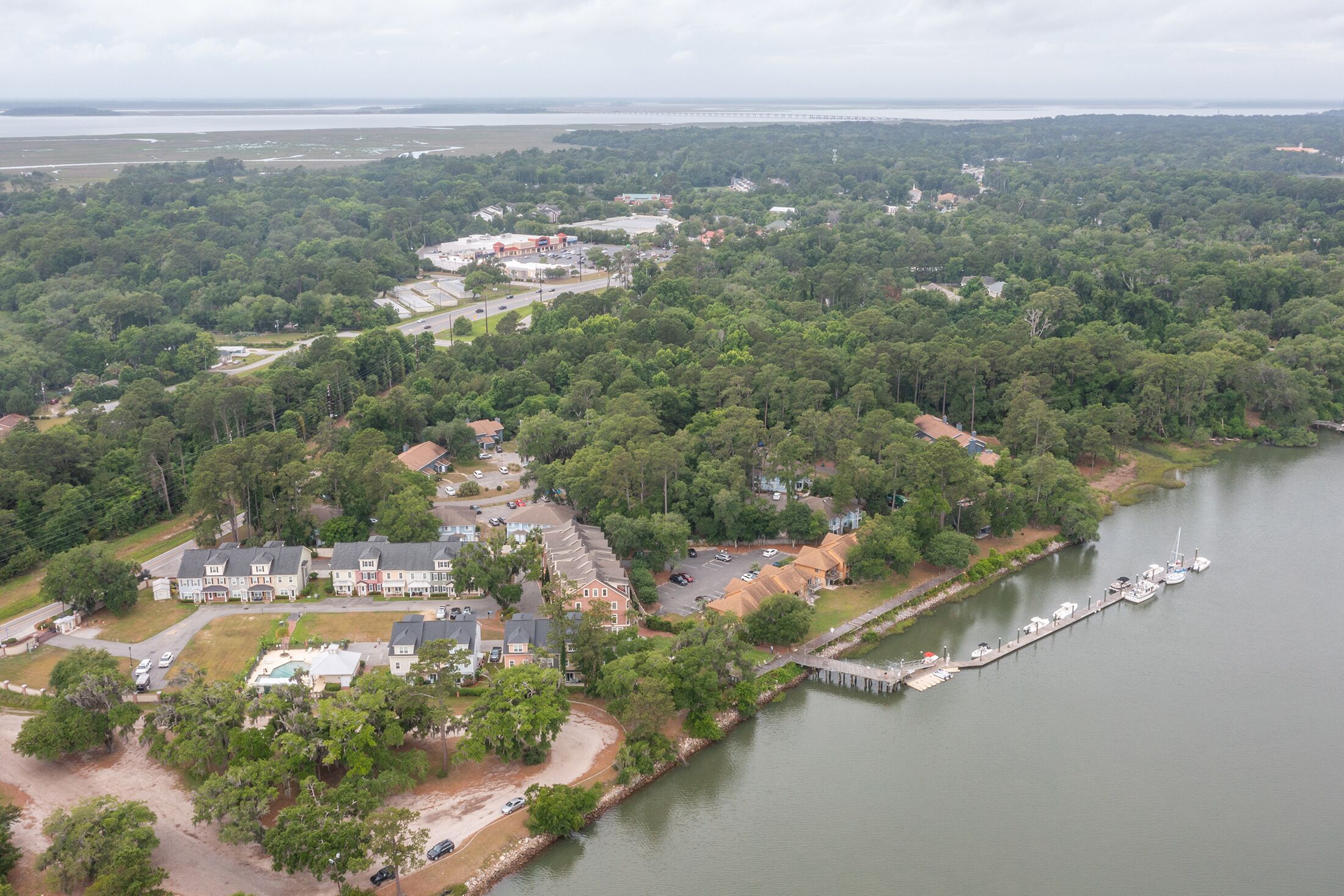 Vista aérea de una zona residencial con casas, un muelle y un puerto deportivo.
