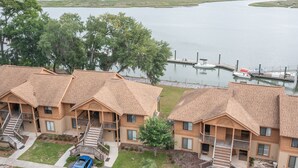 Une rangée de bâtiments en bois dotés de balcons, un quai et une étendue d’eau en arrière-plan.