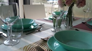 Een gedekte tafel voor een diner, met groene borden, glazen en bestek.