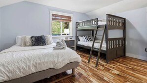 A bedroom with a single bed, a bunk bed, a window with blinds, and a ceiling light. - Luxury CDA home walk to lake with hot tub (Coeur d'Alene)