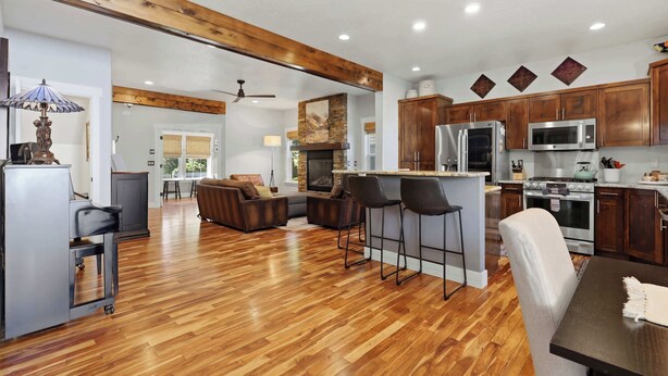 A spacious kitchen with modern appliances, a dining area with a bar, and a living room with a fireplace. - Luxury CDA home walk to lake with hot tub (Coeur d'Alene)