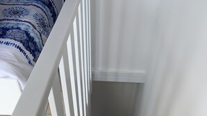 Una escalera con barandas blancas y escalones de madera que lleva a una plataforma.