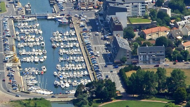 An aerial view of a coastal town with a marina, residential buildings, and a bridge. - Studio Belle Vue Mer (Courseulles-sur-Mer)