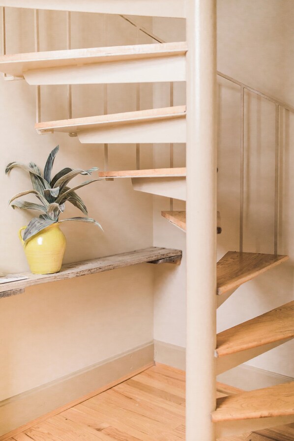 A wooden staircase with a potted plant on the landing. - Voted best interior design property for monthly stays in Mt Adams • Cincinnati (Cincinnati)
