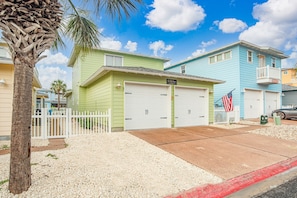 Un barrio residencial con casas, una palmera y una bandera estadounidense.