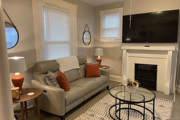 Living space with leather couch, powered recliners, and 65” RokuTV