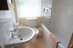 Ein Badezimmer mit Waschbecken, Toilette und Badewanne.