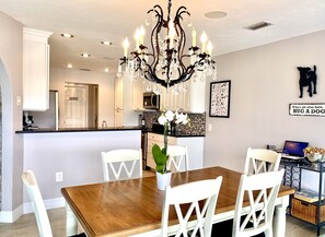 Enjoy meals in this well-equipped kitchen with a central island, microwave and oven, and a dining area with a wooden table and comfortable seating.